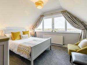 ein Schlafzimmer mit einem weißen Bett und einem Fenster in der Unterkunft Kittiwake in Amble + 22 Fotos