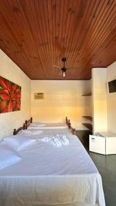 a bedroom with a large white bed with a wooden ceiling at Pousada Casa do Mar Inn Paraty "NOVIDADE" in Paraty