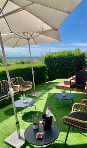 a patio with chairs and tables and an umbrella at Hotel Restaurant Au Riesling in Zellenberg