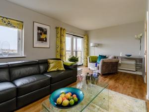 ein Wohnzimmer mit einem Sofa und einer Obstschale auf einem Tisch in der Unterkunft Marina View in Amble