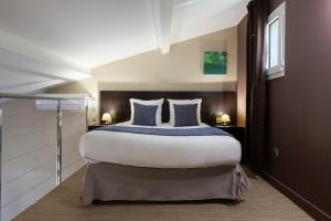 Postel nebo postele na pokoji v ubytování SOWELL HOTELS Domaine de la Petite Isle