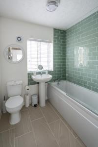 a bathroom with a toilet and a sink and a bath tub at Falcon Cottage in Sleaford