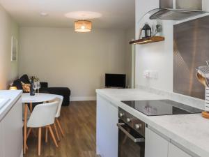a kitchen with a counter top and a table at Peris Lodge - Uk47606 in Caernarfon