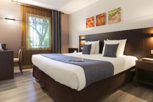 Postel nebo postele na pokoji v ubytování SOWELL HOTELS Domaine de la Petite Isle