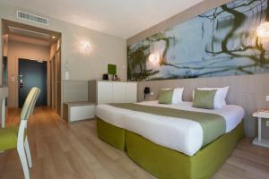 Postel nebo postele na pokoji v ubytování SOWELL HOTELS Domaine de la Petite Isle