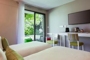 Postel nebo postele na pokoji v ubytování SOWELL HOTELS Domaine de la Petite Isle