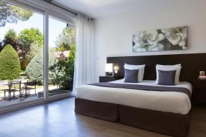 Postel nebo postele na pokoji v ubytování SOWELL HOTELS Domaine de la Petite Isle