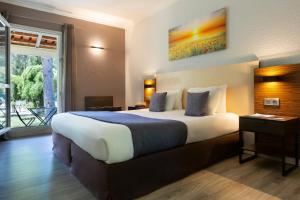 Postel nebo postele na pokoji v ubytování SOWELL HOTELS Domaine de la Petite Isle