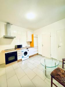 une cuisine avec des appareils blancs et une table en verre dans l'établissement Stylish 2BR apartment Direct City Access, à Vienne 29 autres photos