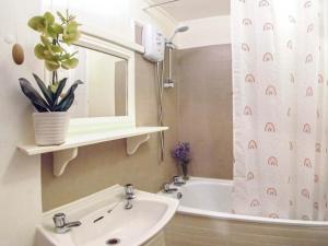 a bathroom with a sink and a shower curtain at Sage Cottage in Truro +7 photos