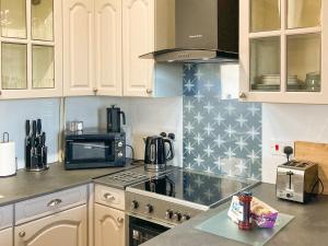 a kitchen with a stove top oven next to a microwave at Sage Cottage in Truro