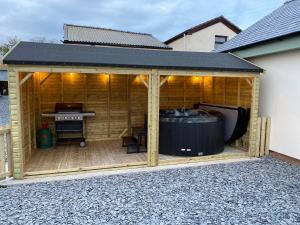 a wooden gazebo with a black roof at Pointer Cottage in Preesall