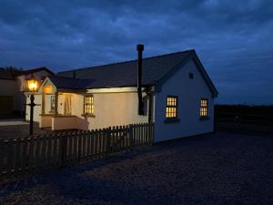 a small white house with a fence and a street light at Pointer Cottage in Preesall