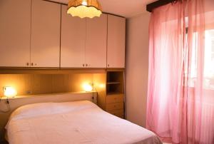 Un dormitorio con una cama y una cortina rosa. en Il giardino Segreto, en Traona 42 fotos más