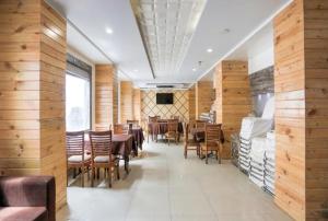 a dining room with wooden walls and tables and chairs at Hotel OK International in Varanasi