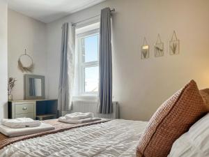 a bedroom with a bed with two towels on it at Alders Cottage in Tansley
