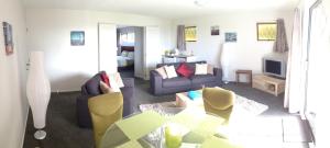 uma sala de estar com um sofá e uma mesa em Baywaterviews em Paihia