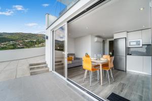 カリェタにあるBrand new private modern apartment with Patio and Sea Viewのテーブルと椅子のあるキッチンとダイニングルーム