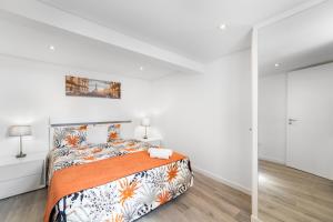 カリェタにあるBrand new private modern apartment with Patio and Sea Viewの白いベッドルーム(オレンジ色の毛布付きのベッド付)