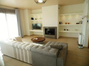 a living room with a couch and a fireplace at Villa Thalassa in Paralía Sergoúlas