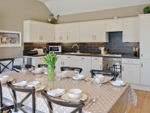 a kitchen with a table and chairs and a kitchen with white cabinets at The Pavillion in Cayton