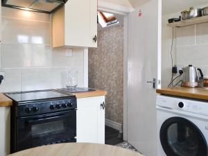 a small kitchen with a stove and a dishwasher at Ashlors in Bridlington