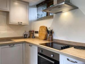 a kitchen with white cabinets and a stove top oven at Wick Mill in Stogursey