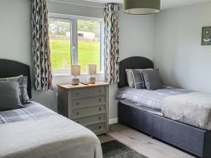 a bedroom with two beds and a window at Rose Lodge - Uk40019 in Halwill +5 photos