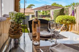 a bottle of wine sitting on a table with glasses at La Gascogne in Andernos-les-Bains