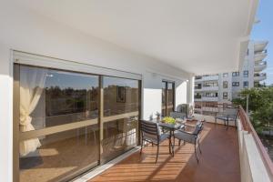 Beca's House في Vau: شرفة مع طاولة وكراسي في مبنى