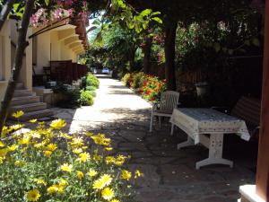 a garden with flowers and a bench and trees at Dalyan Pension in Dalyan
