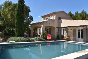a villa with a swimming pool in front of a house at magnificent detached villa with heated swimming pool and jacuzzi, in aureille, in the alpilles – 8 people in Aureille