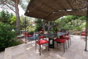 a patio with a table and chairs under an umbrella at magnificent detached villa with heated swimming pool and jacuzzi, in aureille, in the alpilles – 8 people in Aureille