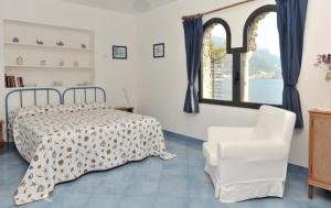 a bedroom with a bed and a chair and a window at La Casetta di Marmorata - Ravello Accommodation in Ravello