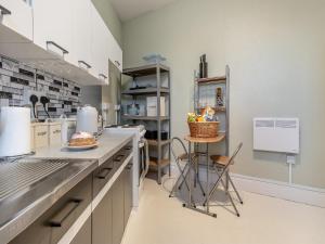 a large kitchen with a counter and a stool at The Flat in Whitchurch