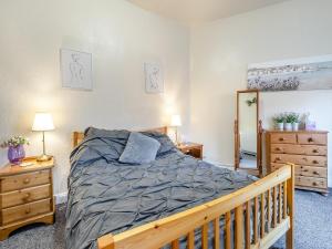 a bedroom with a bed and two dressers and a mirror at The Flat in Whitchurch +6 photos