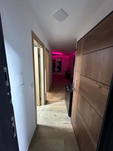 a hallway with a door and a room with pink lights at Nobus Jezerska zvezda A7 in Veliko Gradište