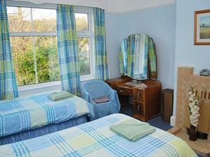 a bedroom with two beds and a chair and a desk at Melville in Bakewell +3 photos