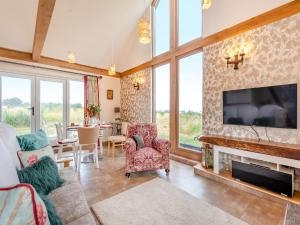a living room with a tv and a fireplace at Blackberry Barn in Maidstone