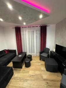 a living room with a couch and a tv at Nobus Jezerska zvezda A7 in Veliko Gradište +6 photos