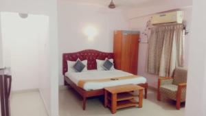 a small bedroom with a bed and a chair at Five Stones By Terra Hotel Mogappair in Chennai
