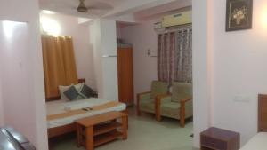 a room with a bed and a couch and a table at Five Stones By Terra Hotel Mogappair in Chennai