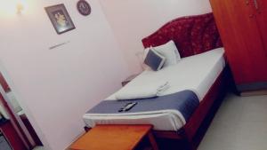 a small bedroom with a bed and a table at Five Stones By Terra Hotel Mogappair in Chennai