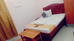 a small bedroom with a bed and a table at Five Stones By Terra Hotel Mogappair in Chennai