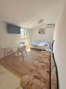 a bedroom with a bed and a table and chairs at Apartments Villa Antony 2 in Drvenik