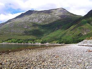 een berg op de achtergrond met een rivier en een berg bij Brightwater Cottage in Arnisdale