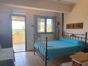 una camera da letto con un letto e una porta su un balcone di Managros Rooms - Studio Thea a Chorí