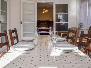 a dining room table with plates and glasses on it at Botany Bay Bungalow in Kingsgate
