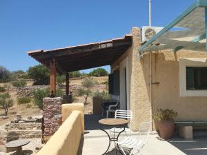 un patio di una casa con tavolo e sedie di Managros Rooms - Studio Thea a Chorí