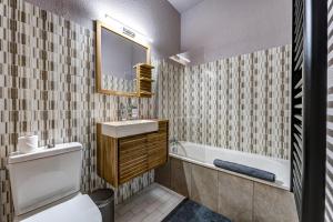 Un baño con lavabo, bañera e inodoro. en Superbe appartement hyper-centre, en Chamonix-Mont-Blanc 12 fotos más